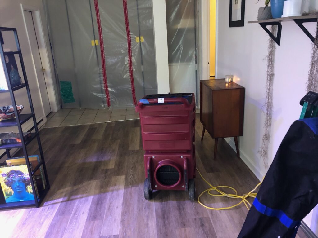 Air Care containment and HEPA air scrubber set up in a finished basement during mold remediation